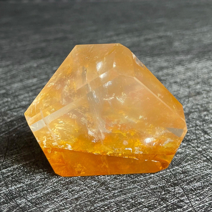 Polished Fire Quartz freeform crystal, glowing with warm orange and amber iron oxide inclusions, promoting energy and balance.