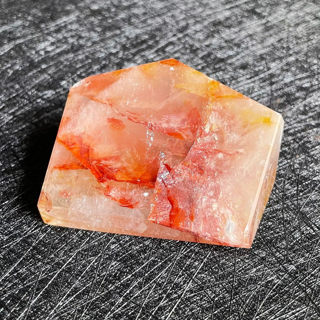 Polished Fire Quartz freeform crystal with warm red, orange, and amber iron oxide inclusions glowing within clear quartz.