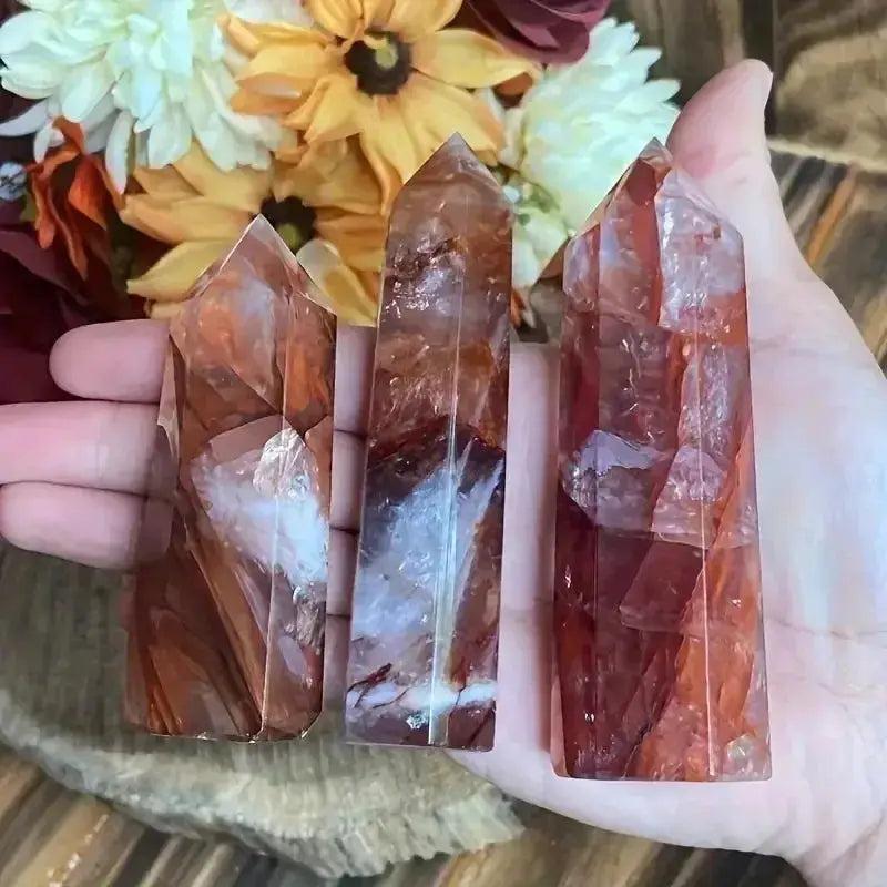 Crystal Destiny Fire Quartz towers with red and orange hues, polished single-point design, held in a hand.