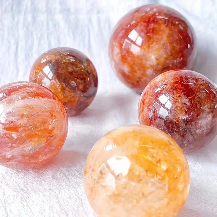 Fiery red-orange Fire Quartz Hematoid spheres from Crystal Destiny, showcasing unique iron oxide patterns.