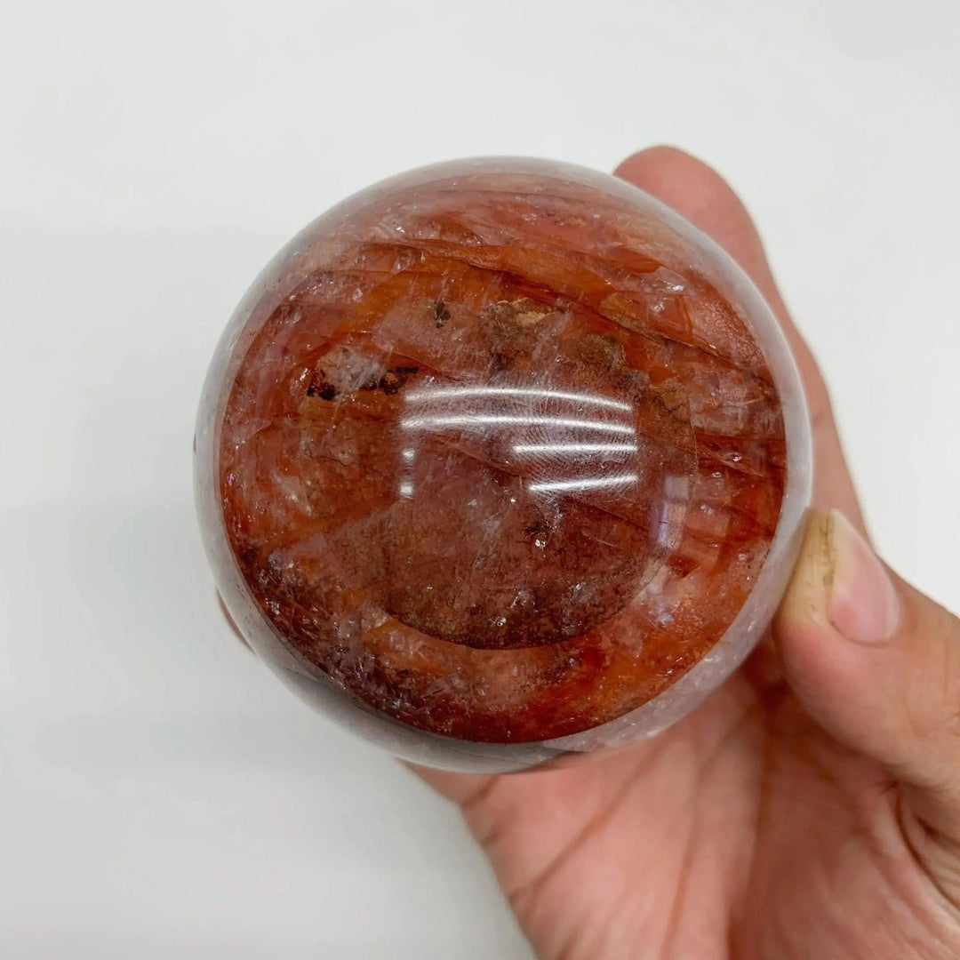 Polished Fire Quartz Hematoid Sphere from Crystal Destiny, showcasing fiery red-orange inclusions and grounding energy.