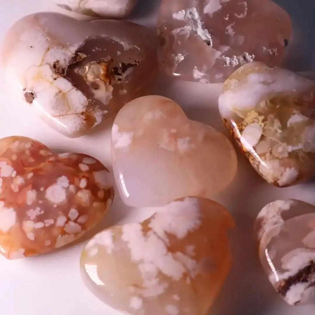 Polished Flower Agate hearts featuring soft pink and white blossom plumes, perfect for Heart Chakra healing and love.