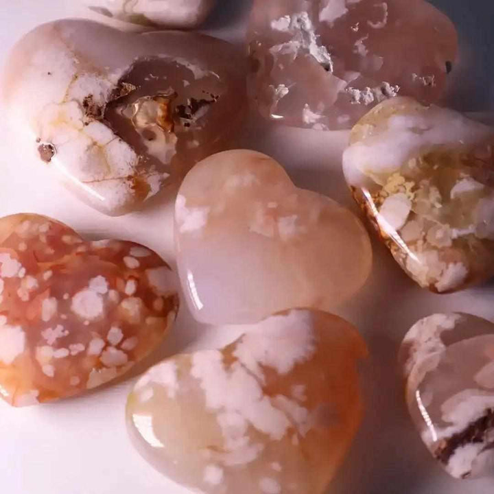 Polished Flower Agate hearts featuring soft pink and white blossom plumes, perfect for Heart Chakra healing and love.