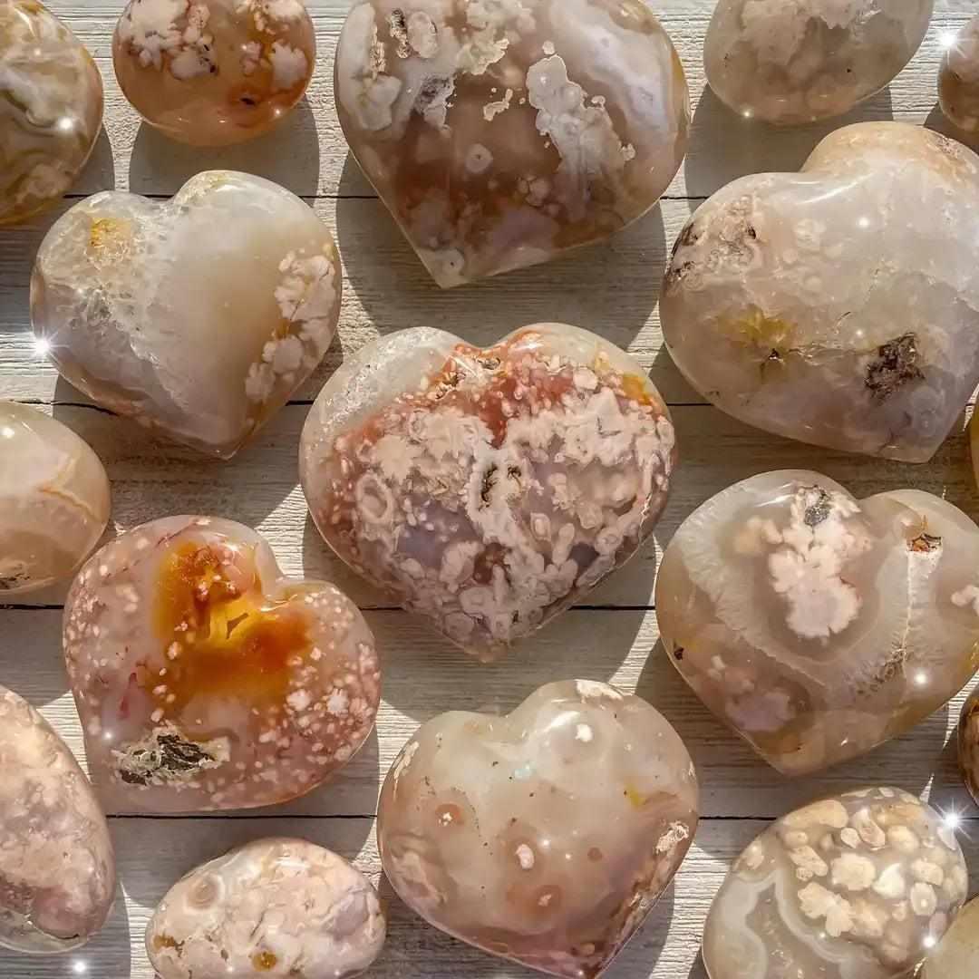 Polished Flower Agate hearts featuring soft pink and white floral plumes, perfect for Heart Chakra healing and love.
