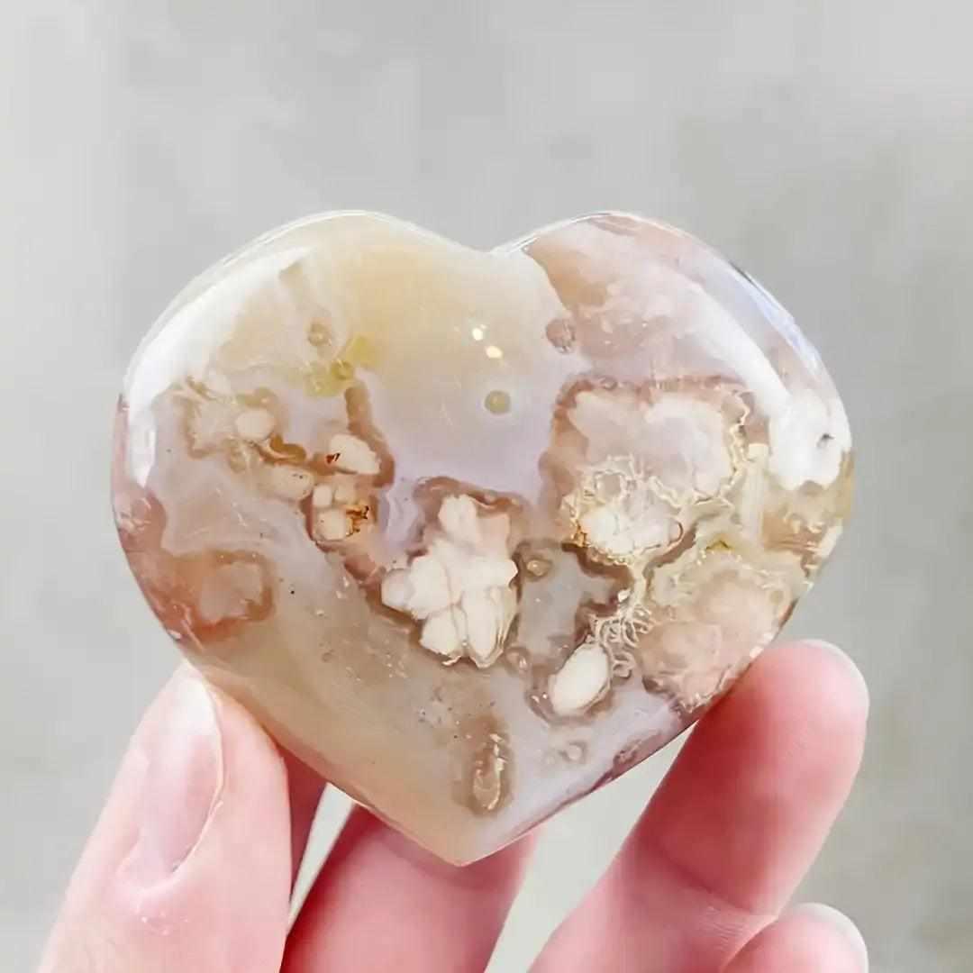 Polished Flower Agate heart featuring soft pink and white blossom plumes for Heart Chakra healing and self-love.