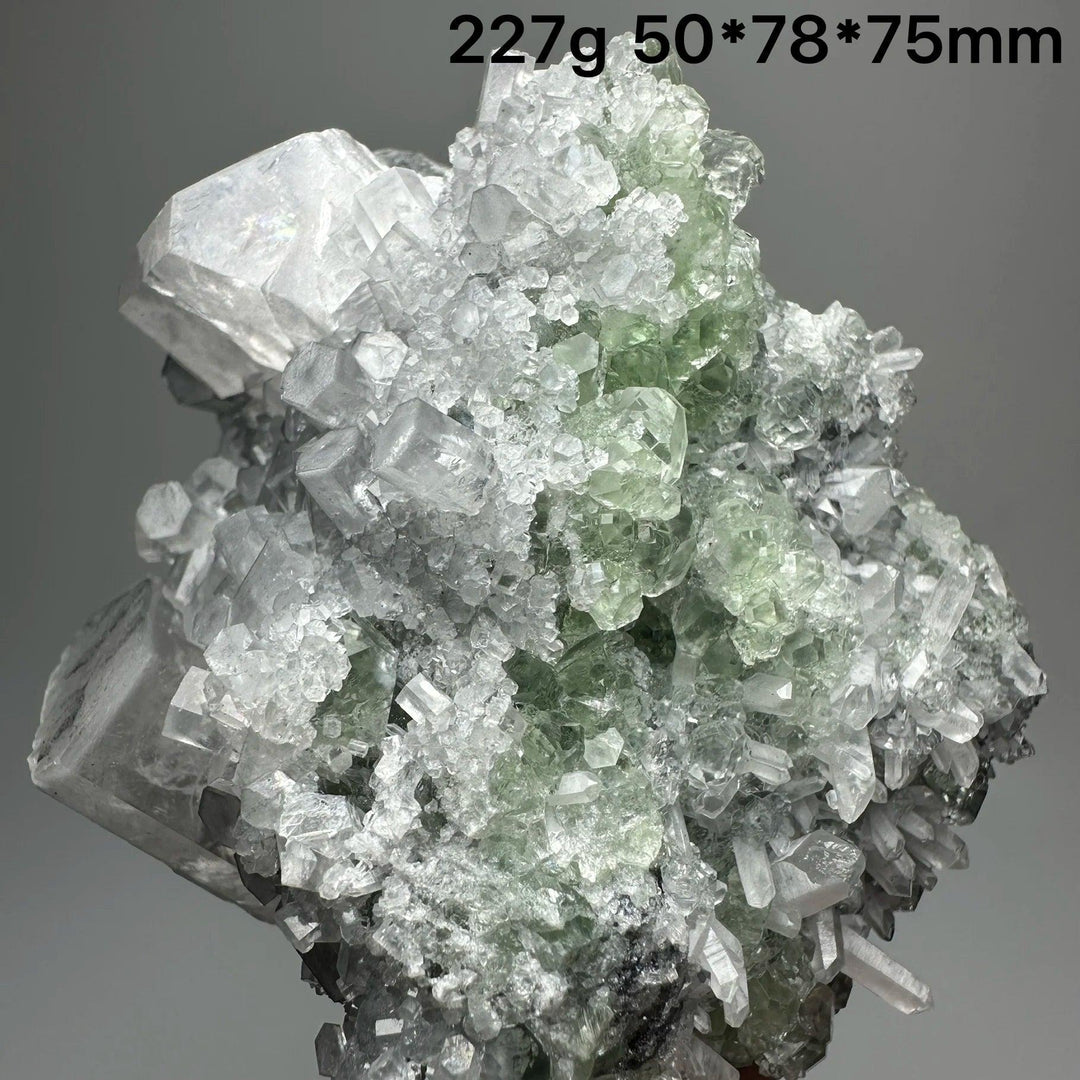 Raw columnar calcite crystal cluster with transparent green and white healing stones.
