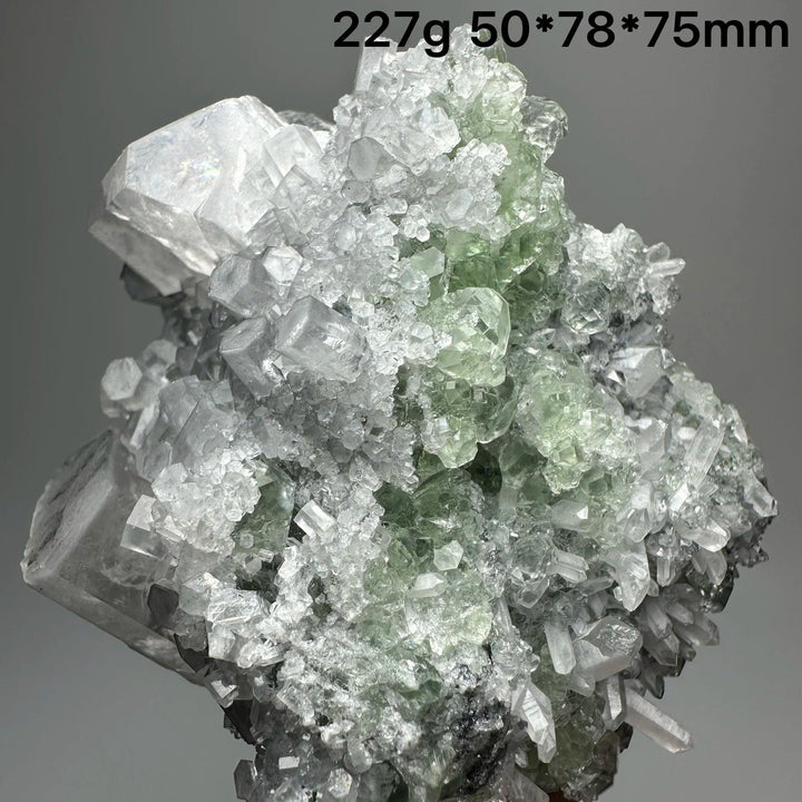 Raw columnar calcite crystal cluster with transparent green and white healing stones.