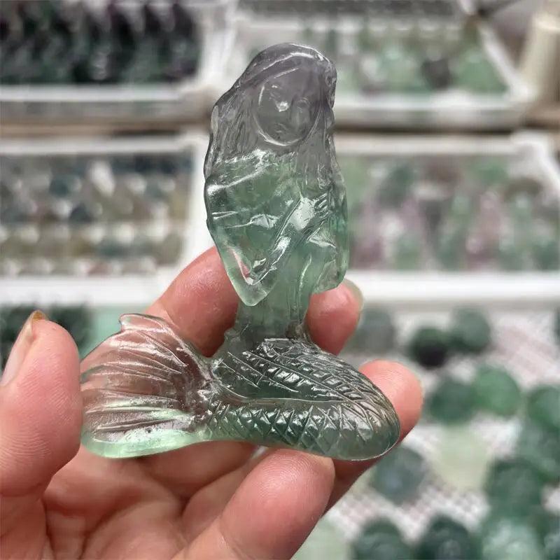 Hand-carved natural fluorite mermaid crystal, featuring beautiful green and purple hues for healing and home decor.