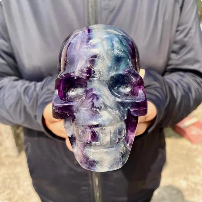 Large Rainbow Fluorite crystal skull, carved with flowing bands of purple, blue, green, and cream.