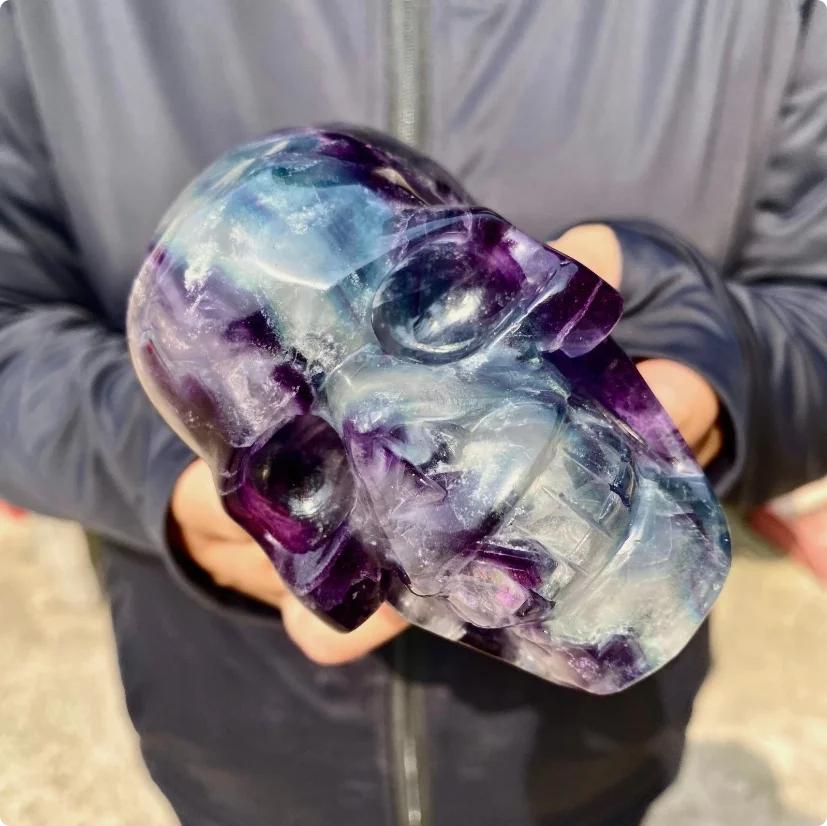 Large Rainbow Fluorite crystal skull, carved with flowing bands of purple, blue, green, and cream.