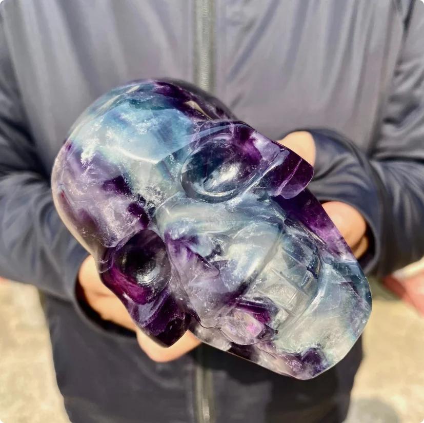 Large Rainbow Fluorite crystal skull, carved with flowing bands of purple, blue, green, and cream.
