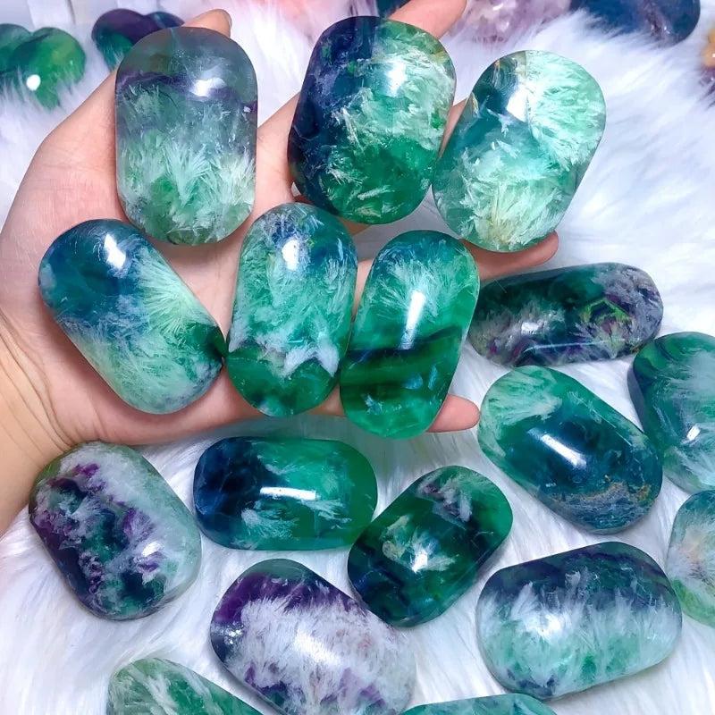 Polished feather snowflake fluorite palm stone with vibrant green and purple hues, perfect for healing and meditation.