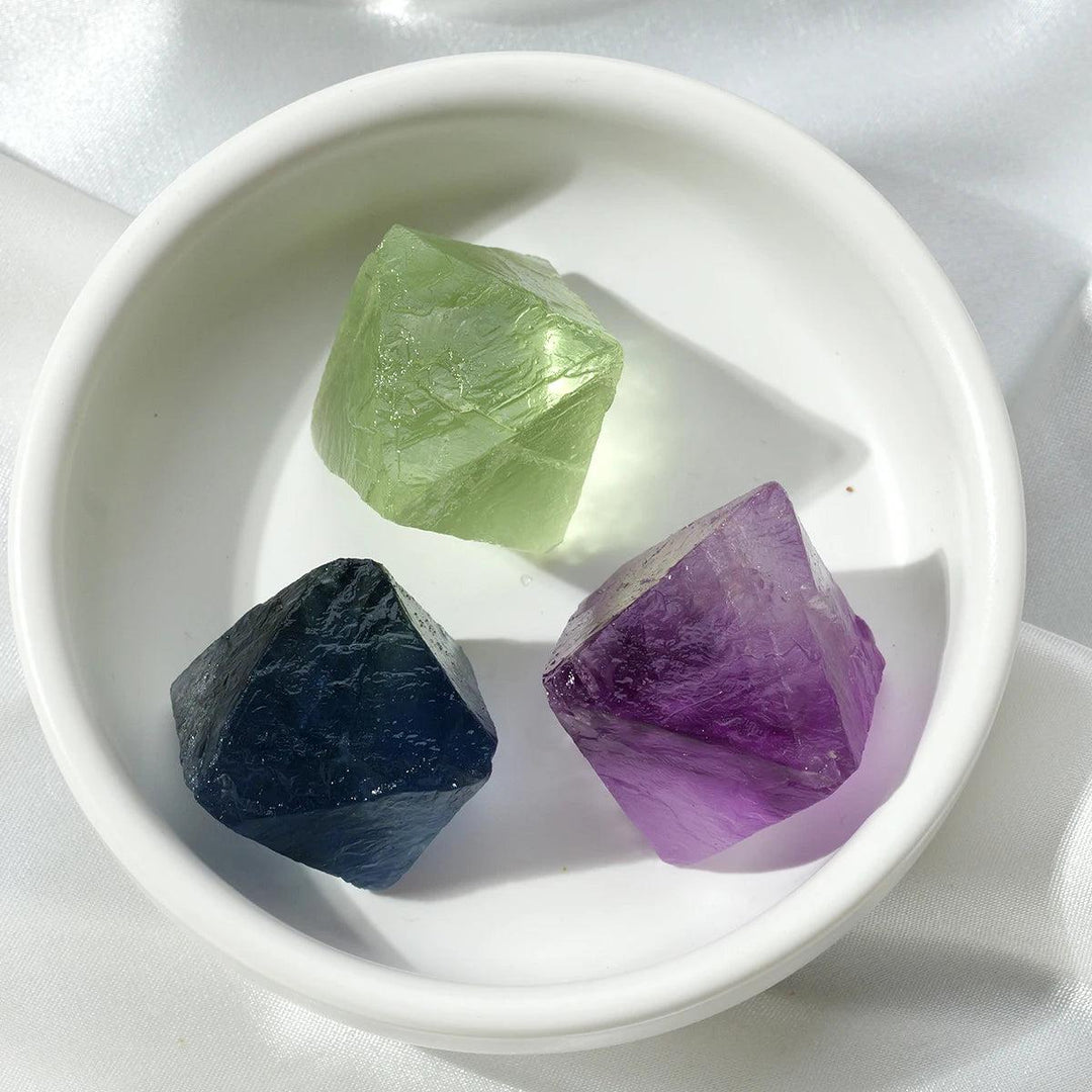 Raw Fluorite Crystal Octahedron: natural green, blue, and purple stones in a white bowl, perfect for healing.