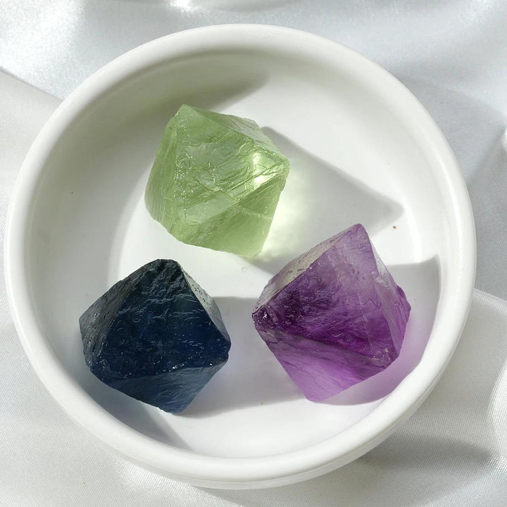 Raw Fluorite Crystal Octahedron: natural green, blue, and purple stones in a white bowl, perfect for healing.
