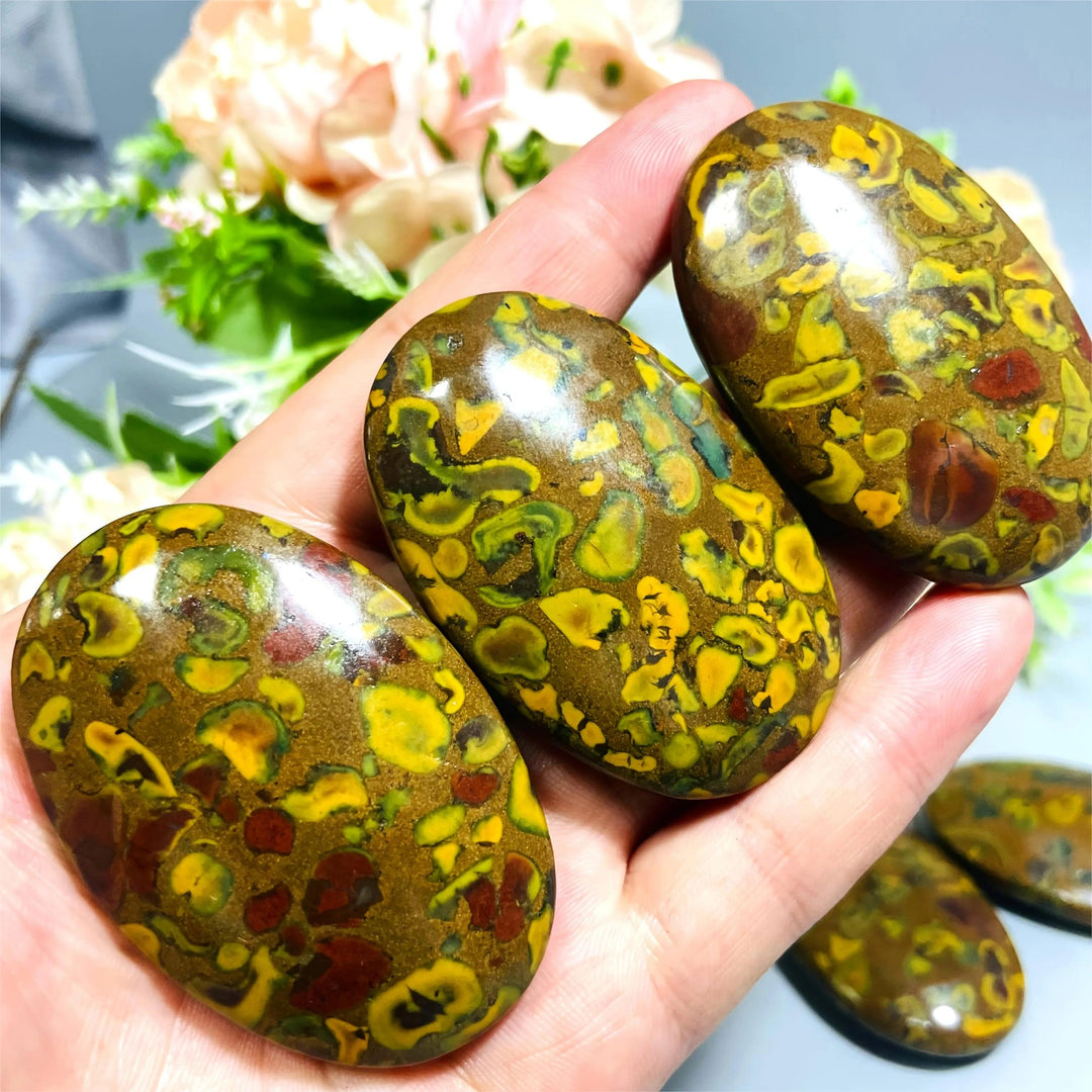Polished Fruit Jasper Crystal Palm Stones with vibrant green, yellow, and red swirls for grounding and healing.