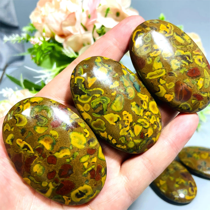 Polished Fruit Jasper Crystal Palm Stones with vibrant green, yellow, and red swirls for grounding and healing.