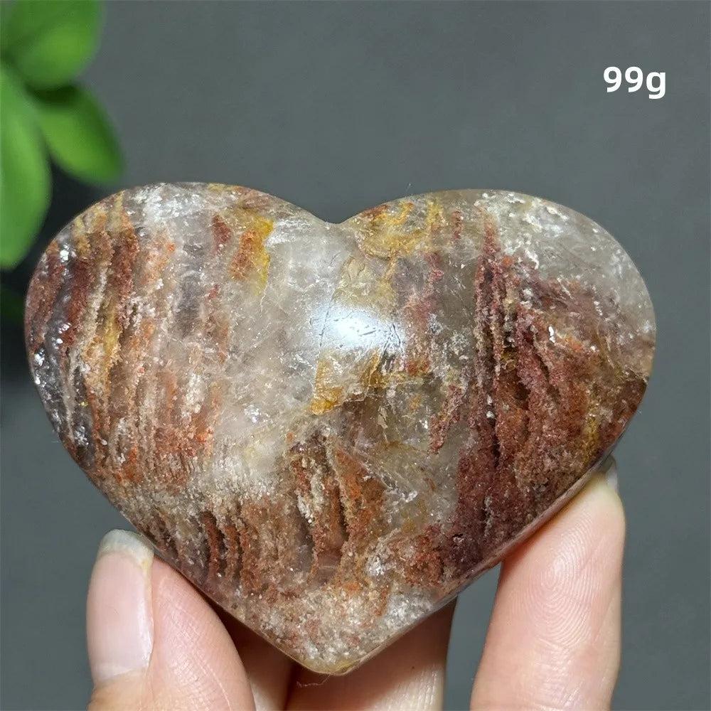 99g heart-shaped natural garden quartz crystal with red inclusions for spiritual healing, meditation, and Feng Shui decor.