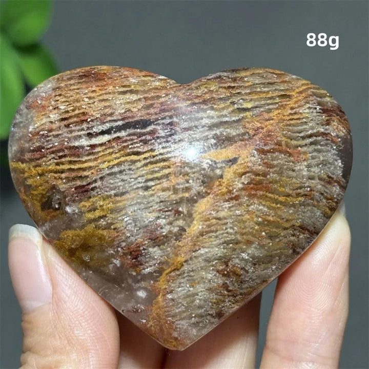 88g natural thousand-layer crystal heart ornament with earthy red and gold banding for spiritual healing and Feng Shui.
