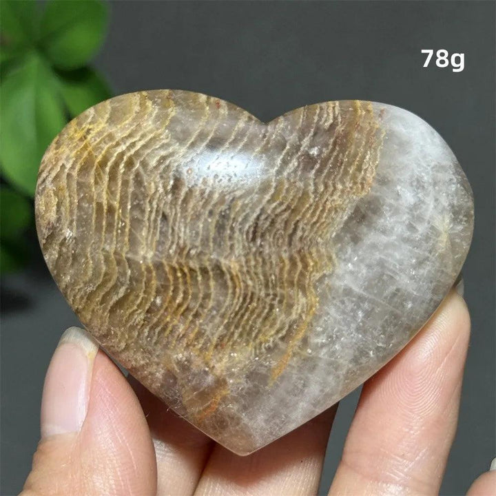 78g heart-shaped Thousand-Layer crystal ornament with natural golden banding for spiritual healing and Feng Shui decor.