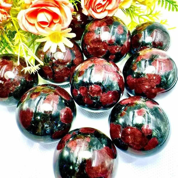 Polished Garnet Astrophyllite spheres featuring golden star-like blades and deep red garnet for grounding and vitality.