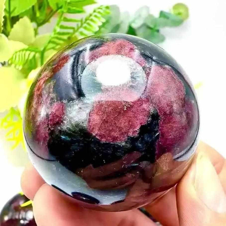 Polished Garnet Astrophyllite sphere featuring golden blades and deep red garnet for grounding and inner transformation.