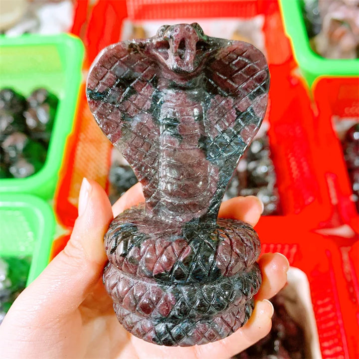 Hand-carved deep red garnet cobra snake sculpture, a powerful crystal for grounding, courage, and vitality.