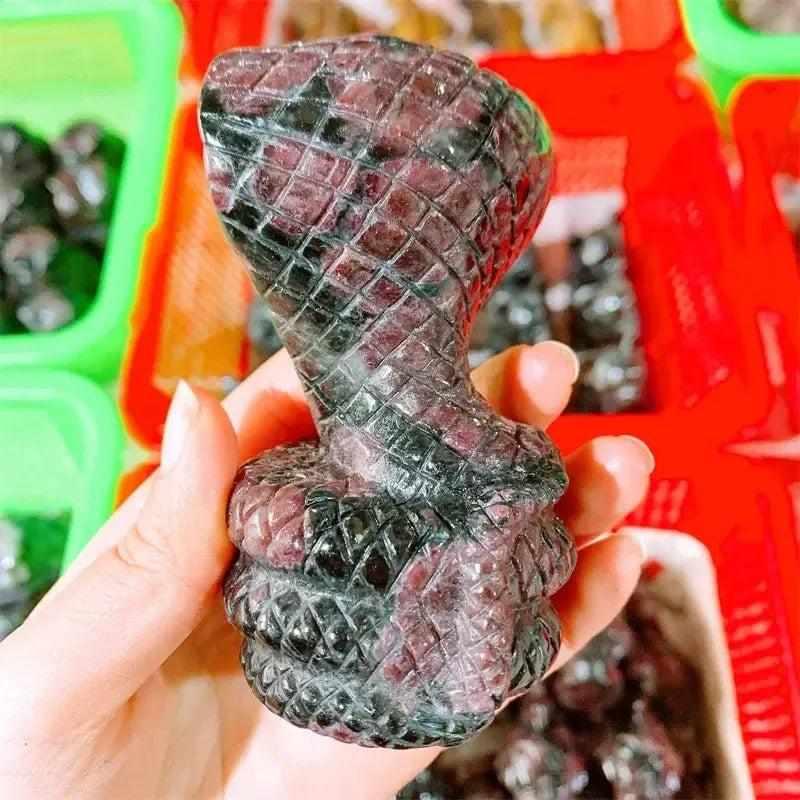 Hand-carved deep red garnet cobra snake sculpture, a powerful crystal totem for courage, vitality, and chakra grounding.