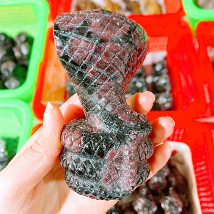 Hand-carved deep red garnet cobra snake sculpture, a powerful crystal totem for courage, vitality, and chakra grounding.