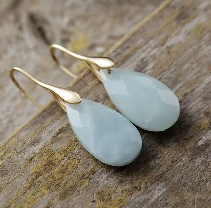 Elegant teardrop Aquamarine gemstone earrings in gold leverbacks, perfect for soothing throat chakra energy.