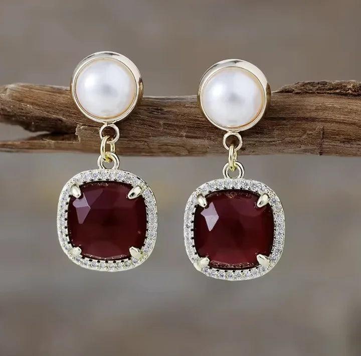 Gemstone Crystal Earrings featuring deep red square stones, pearl accents, and sparkling halo settings for elegant style.