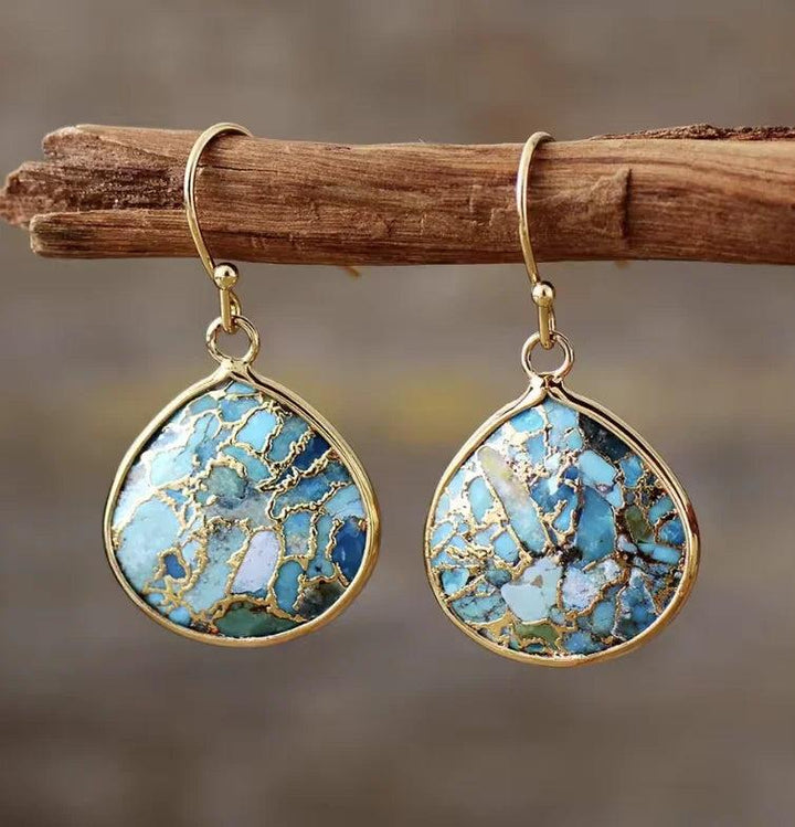 Gold-rimmed Africa Turquoise drop earrings featuring vibrant blue and green healing gemstone patterns.
