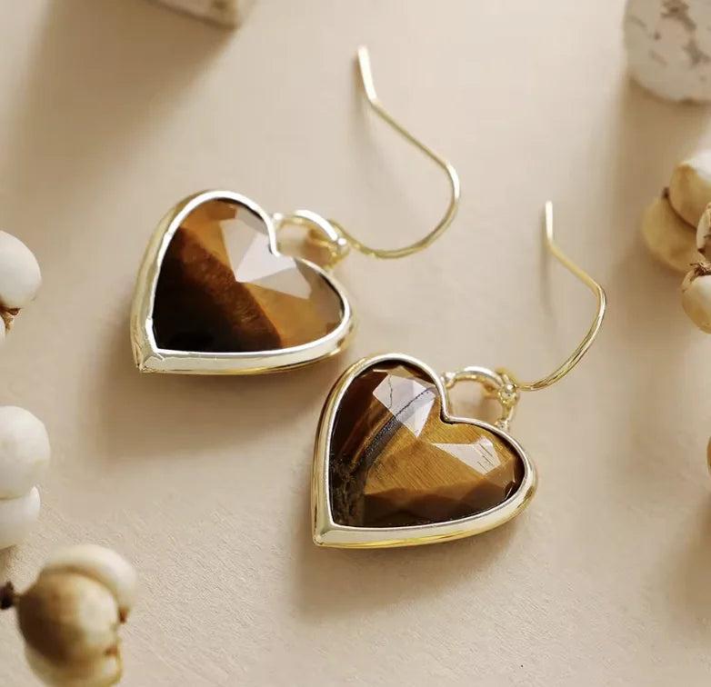 Heart-shaped Tiger's Eye gemstone drop earrings in a gold setting, perfect for grounding energy and daily style.