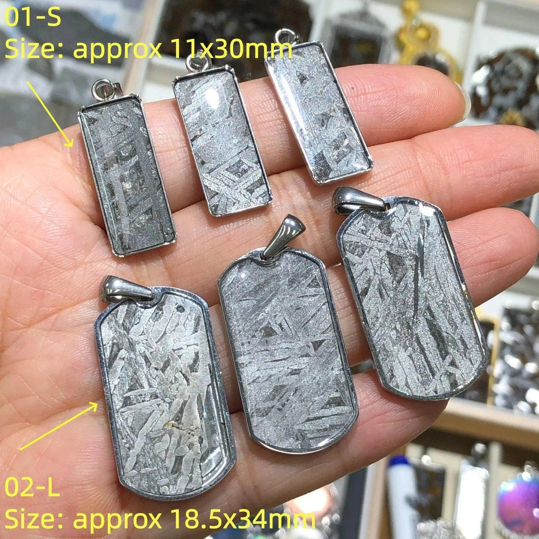 Gibeon meteorite pendants in stainless steel frames, featuring unique silver Widmanstatten patterns for cosmic grounding.