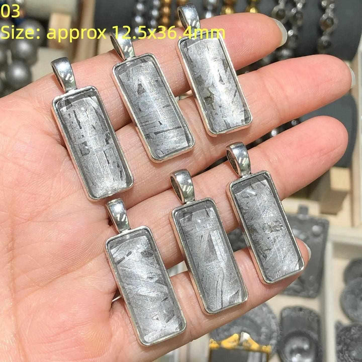 Gibeon meteorite rectangle pendants in stainless steel frames, featuring unique silver Widmanstatten crystalline patterns.