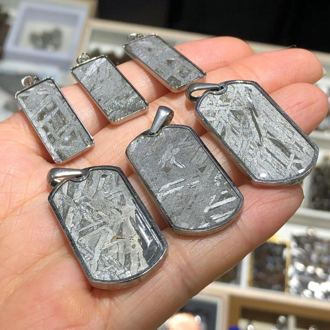 Gibeon meteorite rectangle pendants in stainless steel frames, showcasing unique Widmanstatten patterns for cosmic energy.