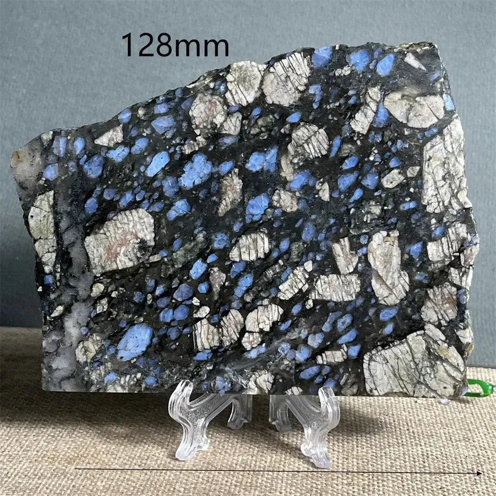 Glaucophane Slab, a natural blue crystal specimen, 128mm wide, with deep blue-gray and white inclusions on a display stand.
