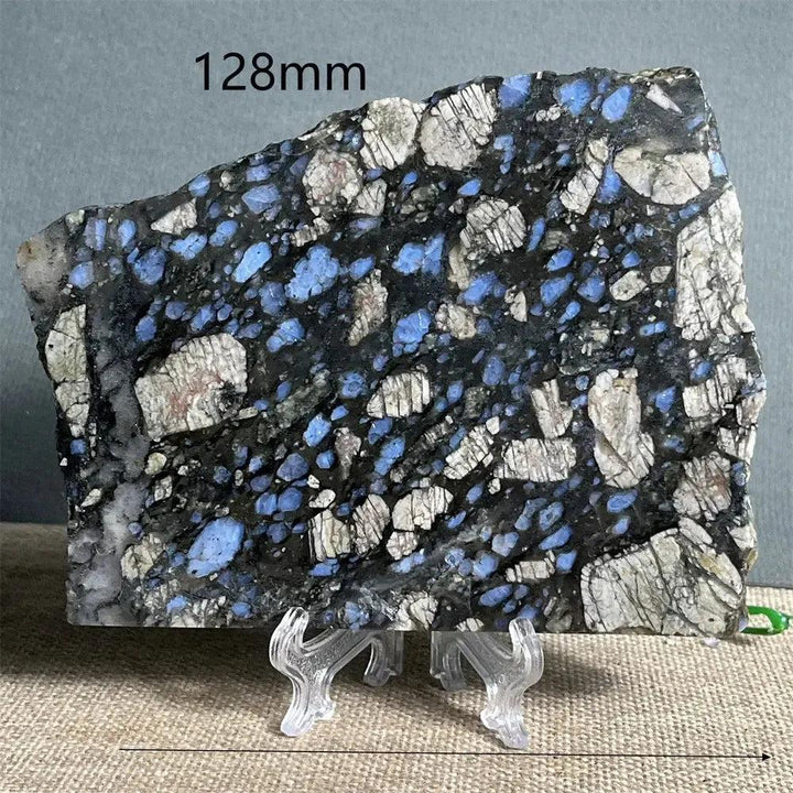 Glaucophane Slab, a natural blue crystal specimen, 128mm wide, with deep blue-gray and white inclusions on a display stand.