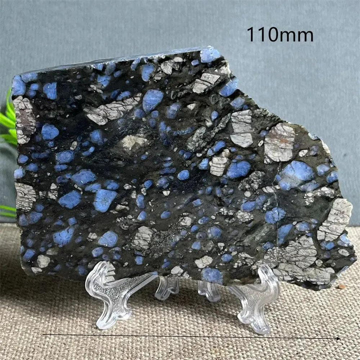 Glaucophane slab from Crystal Destiny, a natural blue-gray crystal specimen on a clear stand, 110mm wide.