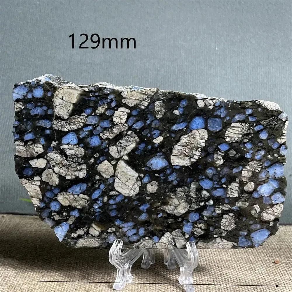 Polished Glaucophane slab from Crystal Destiny, featuring deep blue-gray and white patterns, 129mm wide on a stand.