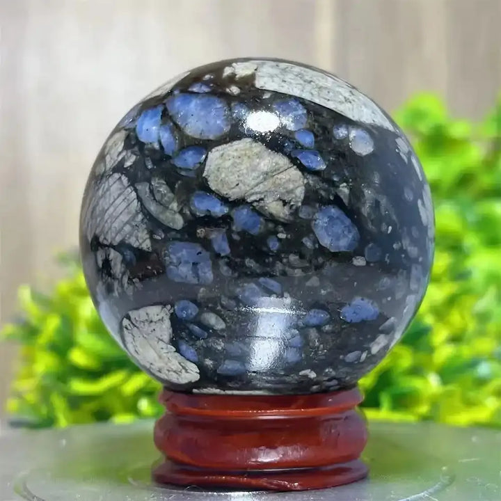 Polished Glaucophane sphere featuring blue and grey mineral inclusions for Reiki healing and spiritual home decor.