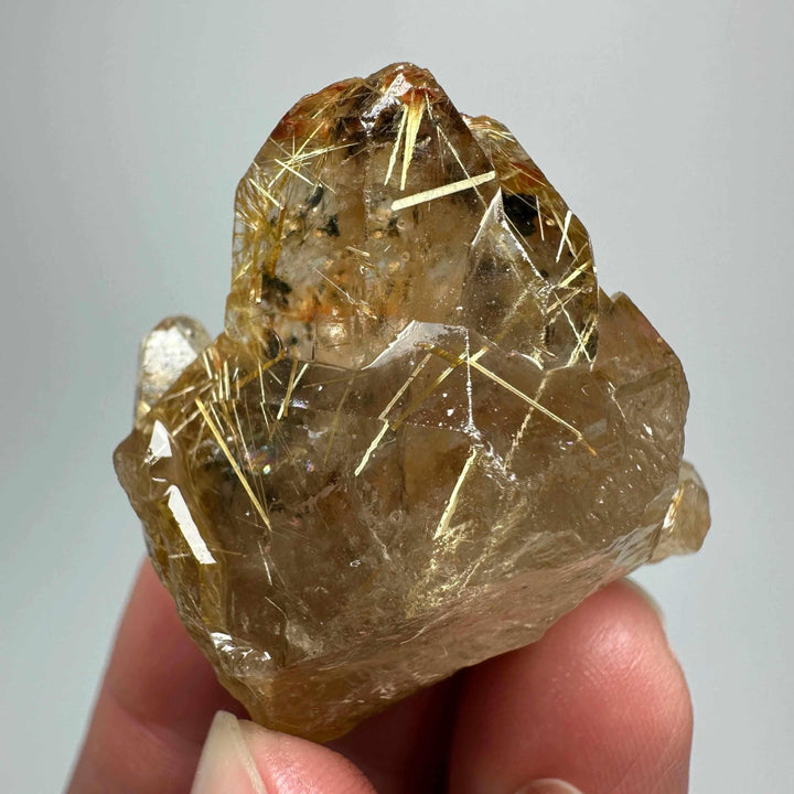 Gold rutilated quartz and specular hematite specimen with golden needles and metallic sheen for chakra balancing.