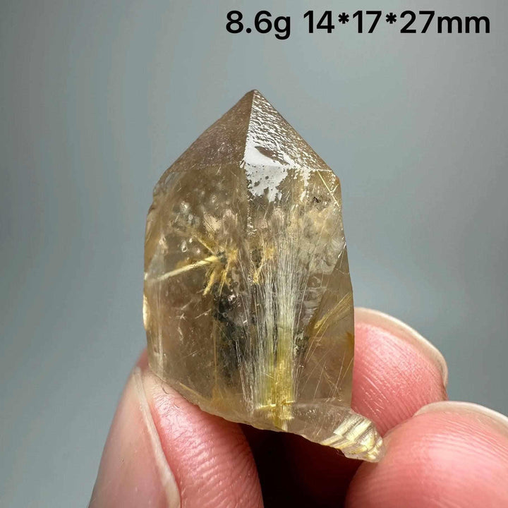 Gold rutilated quartz and specular hematite crystal point with golden needles and metallic sheen for solar plexus healing.