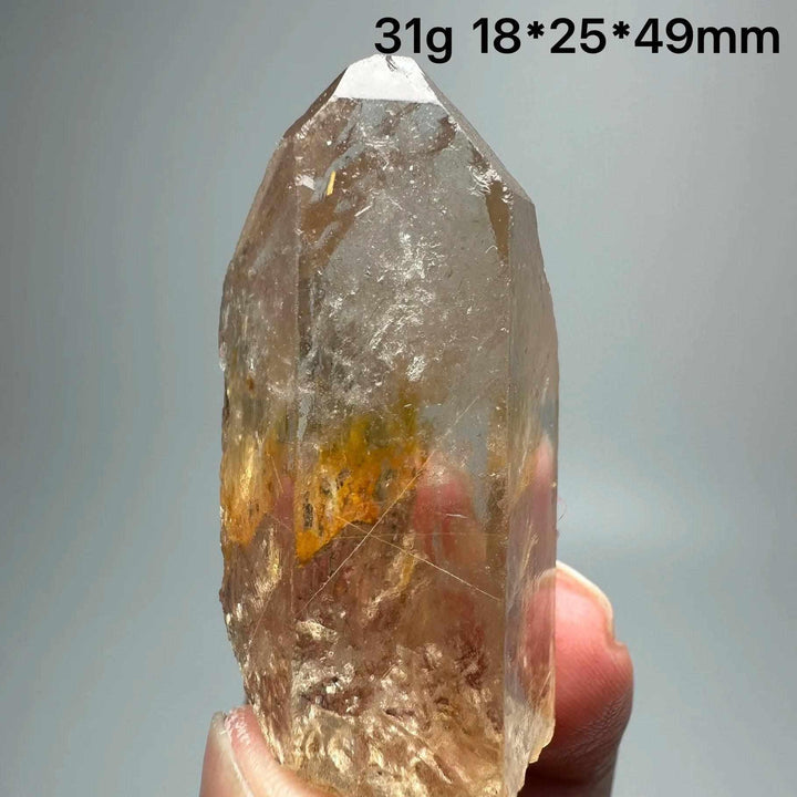 Gold rutilated quartz and specular hematite crystal point with golden needles and metallic sheen for chakra healing.