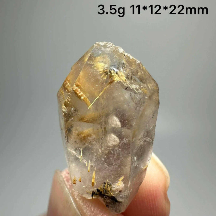 Gold rutilated quartz and specular hematite specimen with golden needles, balancing solar plexus and root chakras.