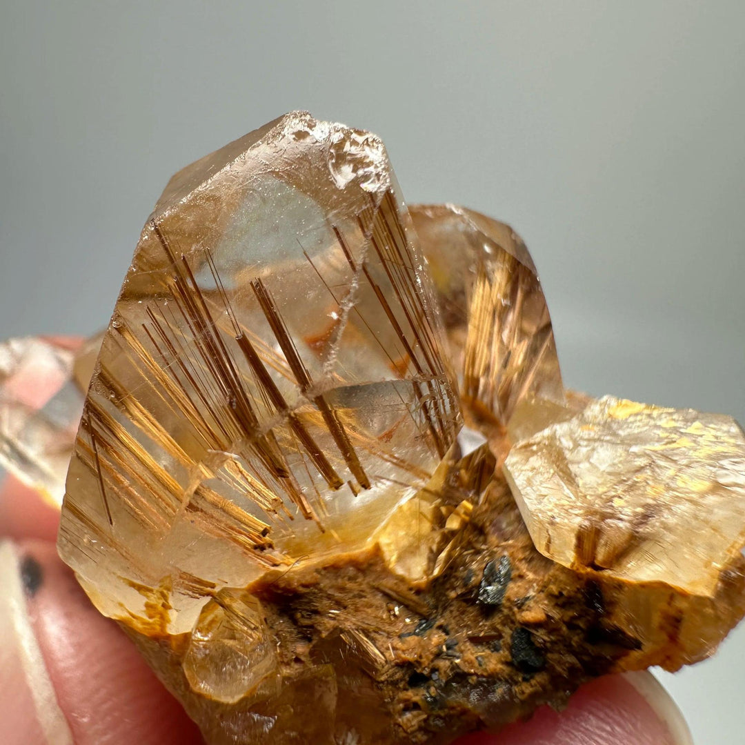 Natural Brazil Gold Rutilated Quartz crystal specimen with golden hair-like inclusions and specular hematite.