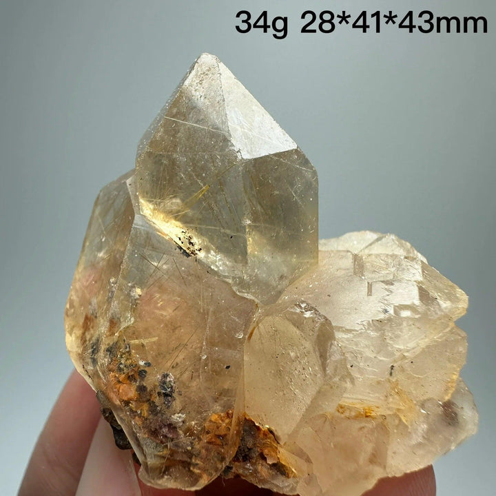 Natural Brazil Gold Rutilated Quartz crystal with specular hematite, featuring clear facets and golden rutile inclusions.