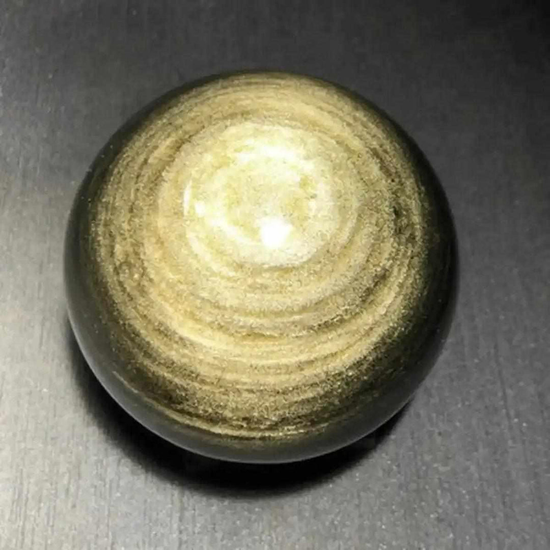 Polished Gold Sheen Obsidian sphere featuring a warm, glowing golden pattern in black volcanic glass for grounding energy.