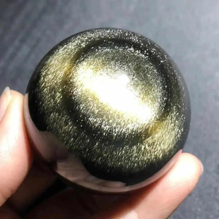 Hand-polished Gold Sheen Obsidian sphere with a radiant golden glow, perfect for grounding and boosting personal power.