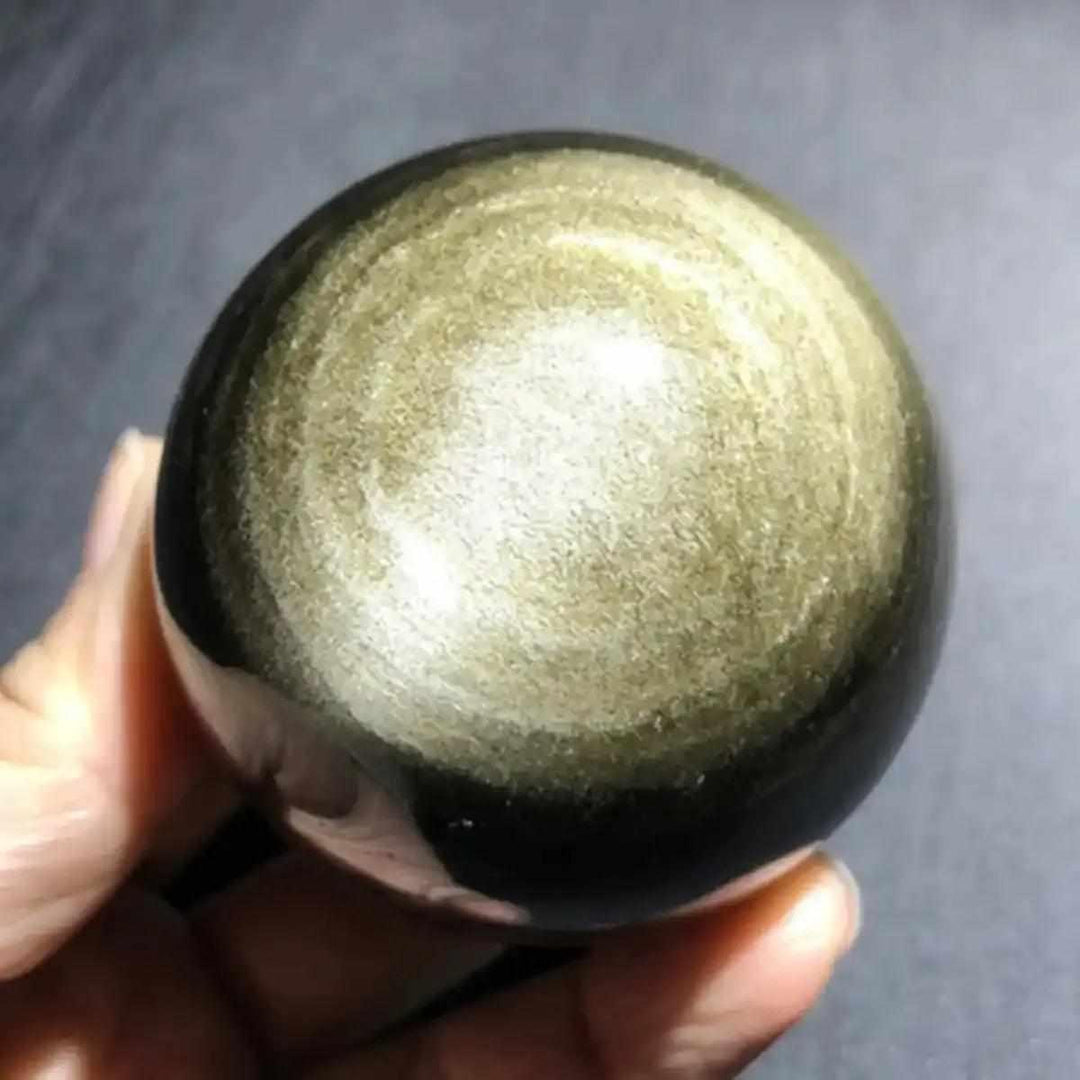 Polished Gold Sheen Obsidian sphere with a radiant golden glow, perfect for grounding and boosting personal confidence.