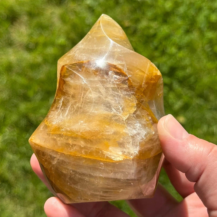 Golden Healer Quartz Crystal Carved Flame, showcasing warm amber gold hues and glowing iron oxide inclusions.